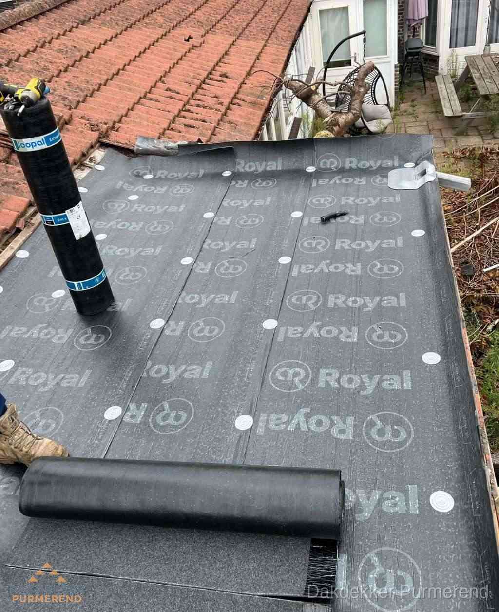 Plat dak met nieuwe bitumen dakbedekking en brandgereedschap in Purmerend