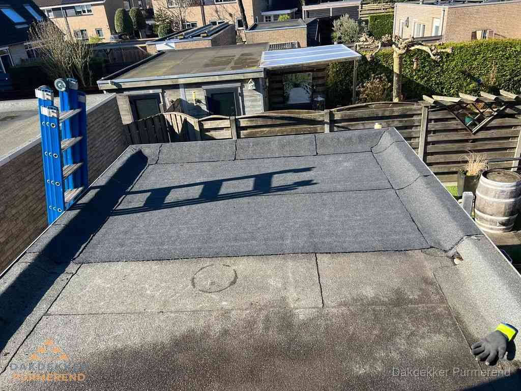 Dakdekker legt onderlaag op plat dak met houten constructie in Purmerend