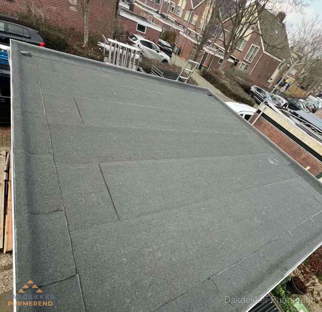 Nieuwe bitumen dakbedekking op plat dak van garage in Purmerend