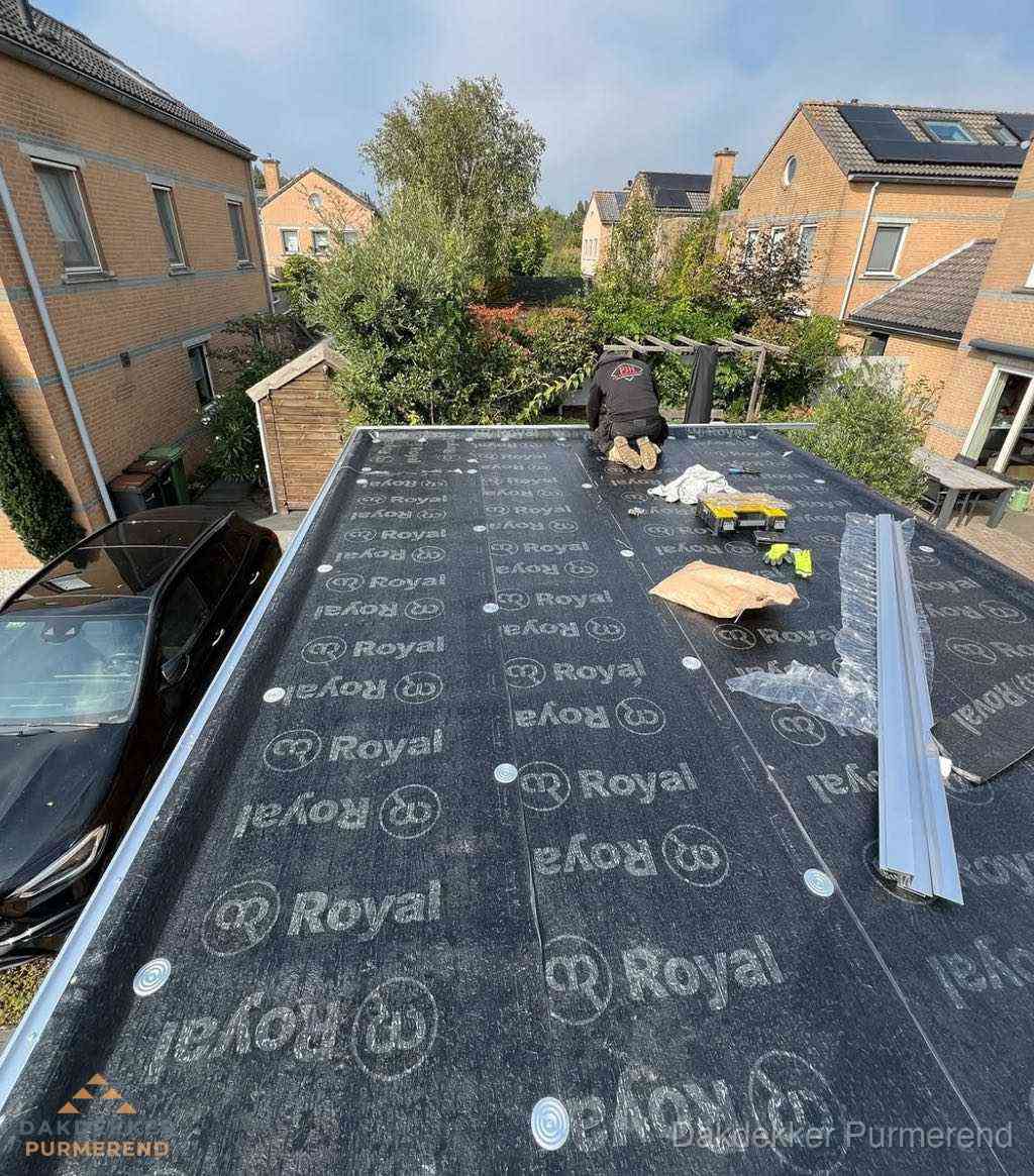 Dakdekker aan het werk op plat dak renovatie in Purmerend