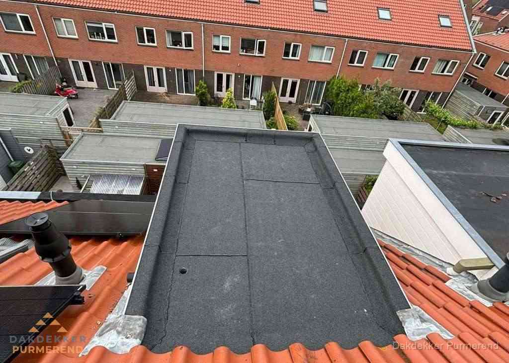 Plat dak met bitumen bedekking naast dakkapel in Purmerend