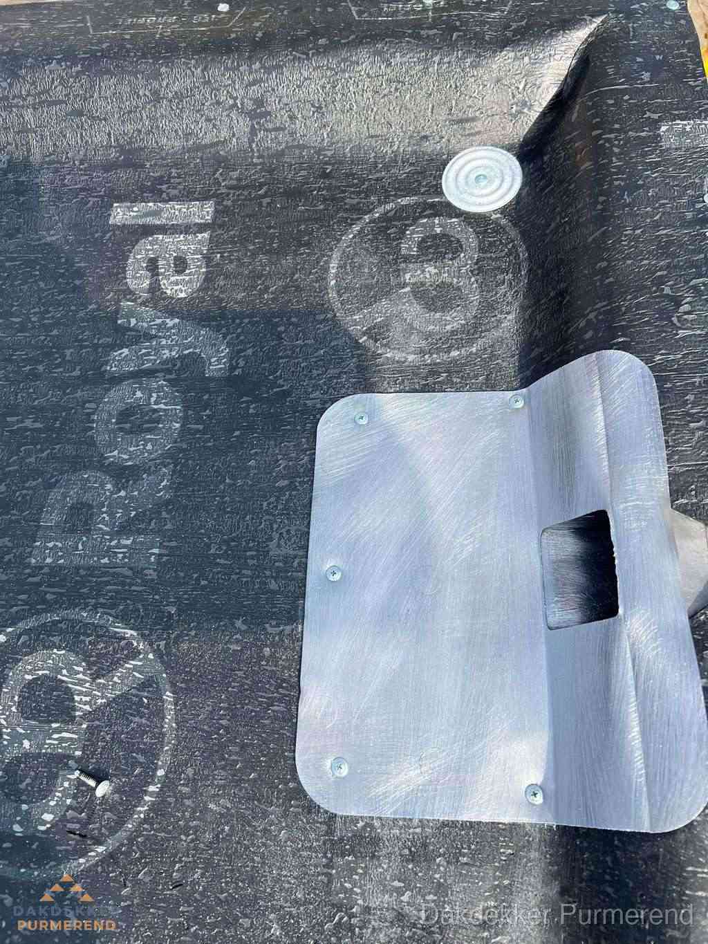 Dakdoorvoer met metalen afvoerplaat op bitumen dak in Purmerend
