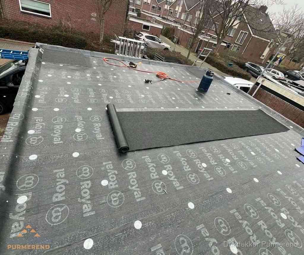 Dakdekker aan het werk met gasbrander op plat bitumen dak in Purmerend