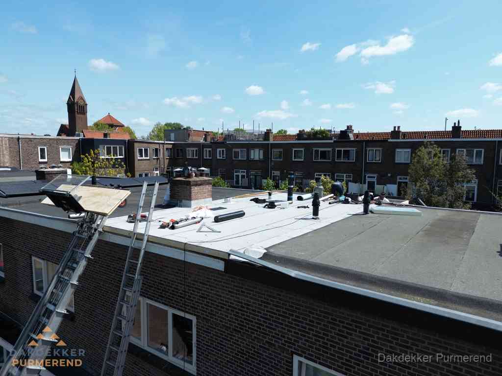 Dakdekkers aan het werk op plat dak in Purmerend